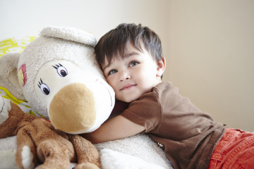 Boy cuddling a teddy