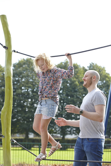 Dad playing with girl on climbing frame