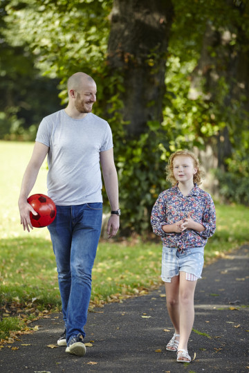 Dad and daughter walking through the park