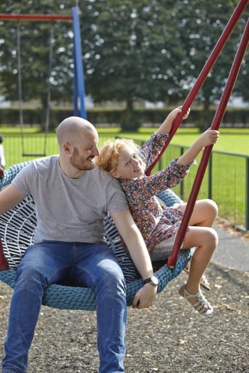 Dad and daughter on swing together