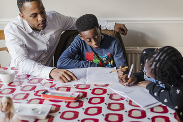 Dad helping son and daughter with homework