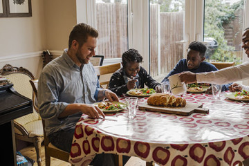 Same sex couple with son and daughter eating at the table