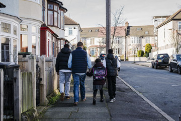 Same sex couple with son and daughter walking to school