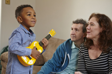 Dad and Mum with son playing guitar