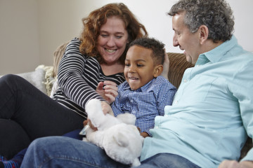 Dad and Mum with son playing with cuddly toy