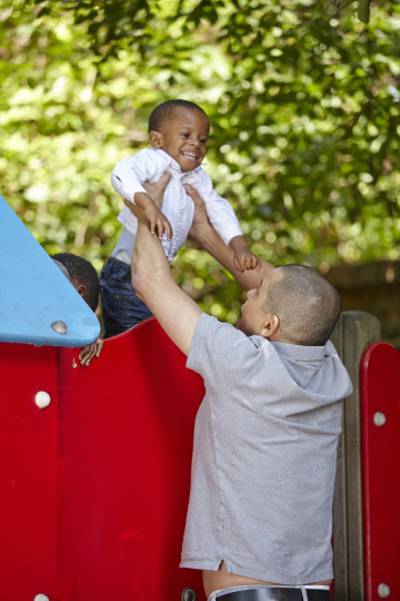 Dad helps son on slide