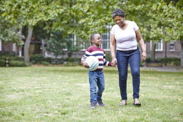 Mum and son in park with football