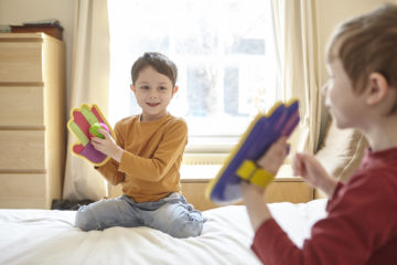Children playing catch on bed