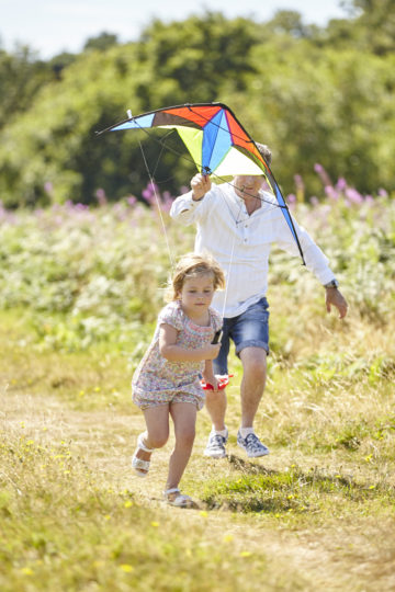 Father and daughter playing with a kite